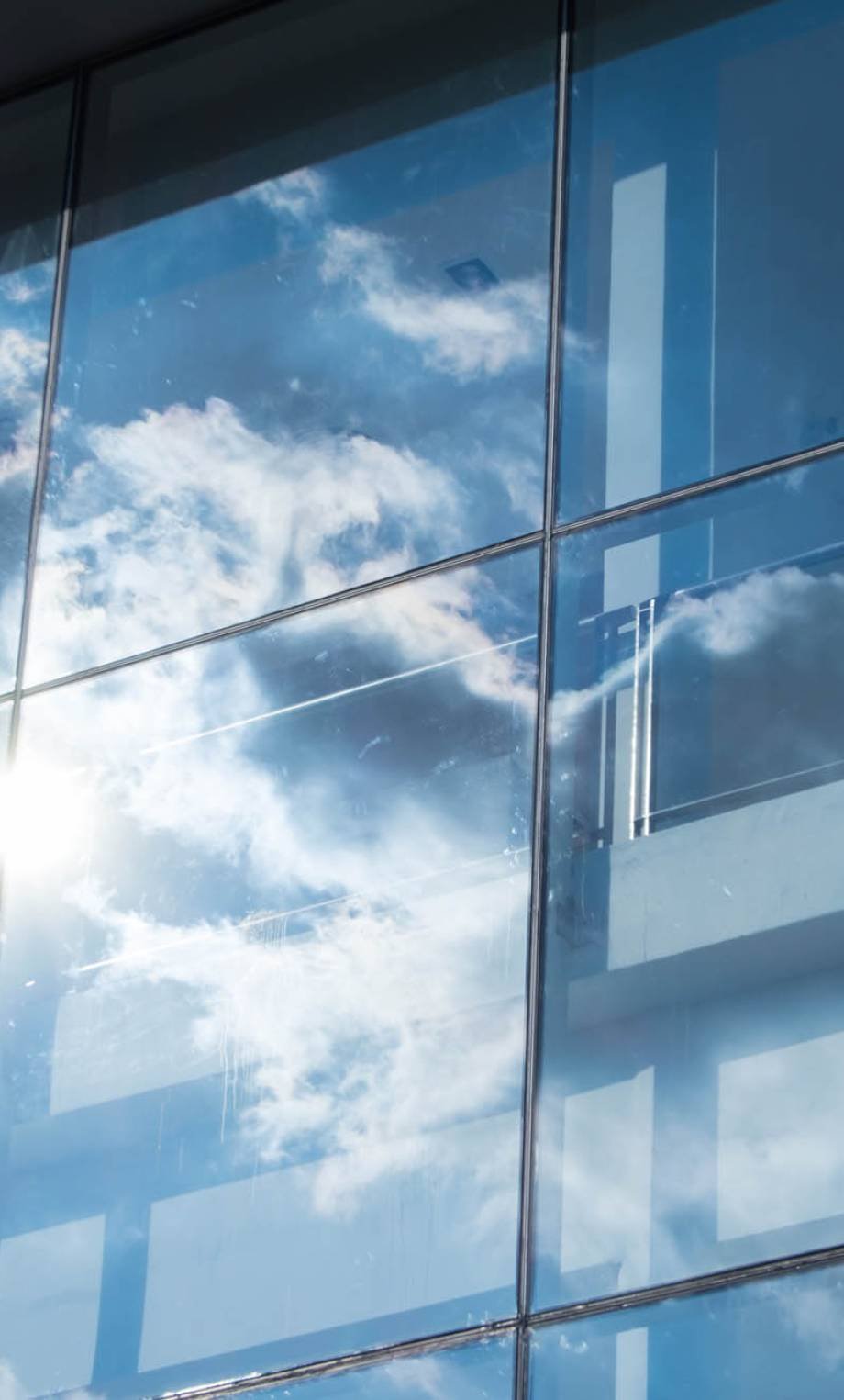 Sun ray and blue sky reflection on window office building, Business concept.